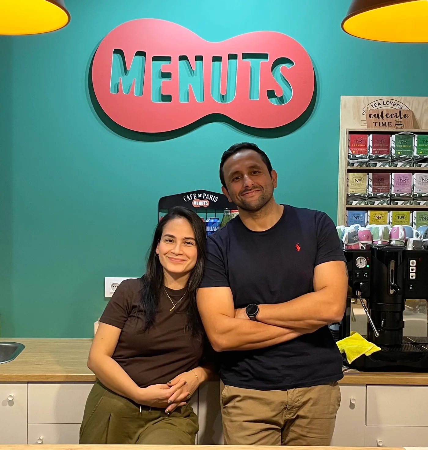 Els fundadors de Menuts, darrere la barra de la cafeteria, sota el logo del club